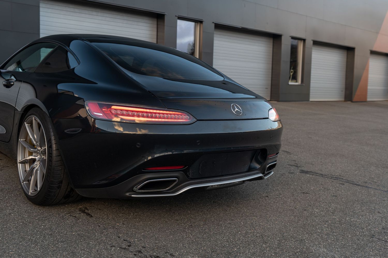 Detail shot of Mercedes-AMG GT rear corner highlighting taillight design and exhaust outlets.