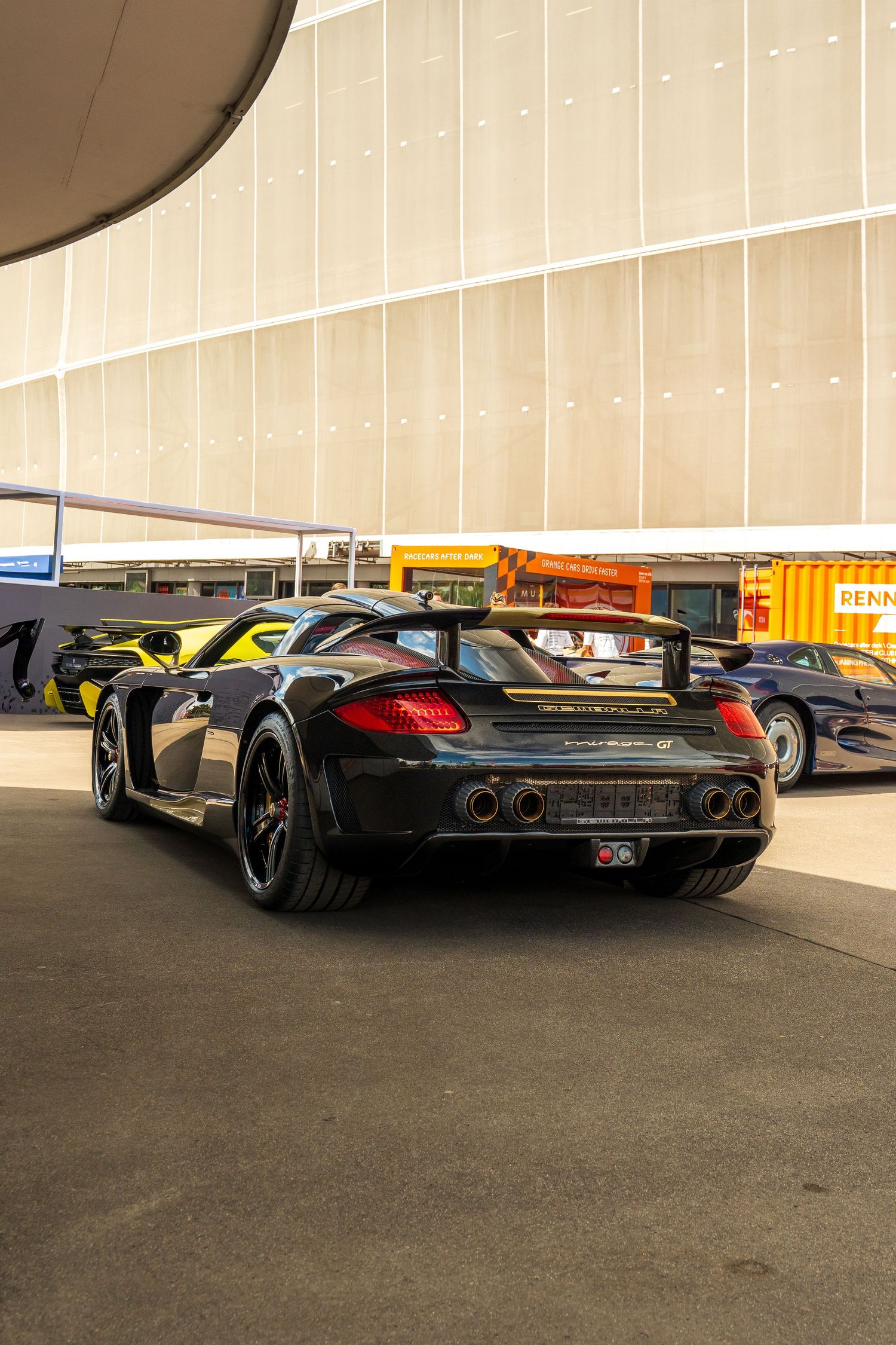 Low-angle view of modified supercars showcasing custom rear diffusers and exhaust systems.