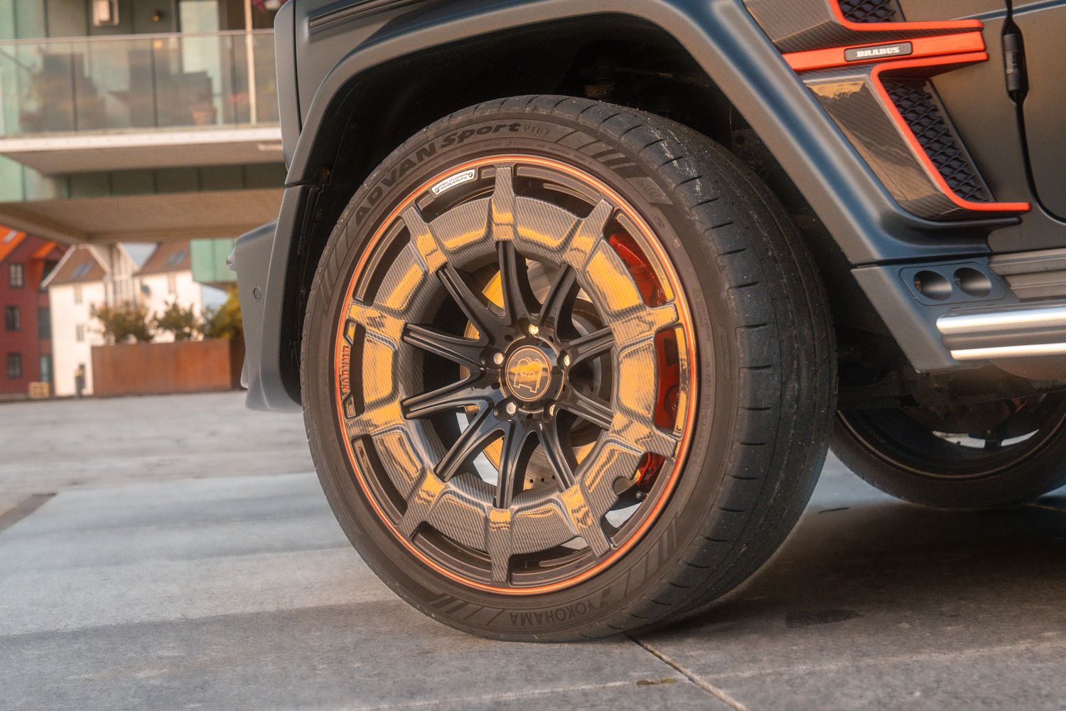 Closeup of modern black and bronze wheels on a luxury vehicle parked in a driveway.