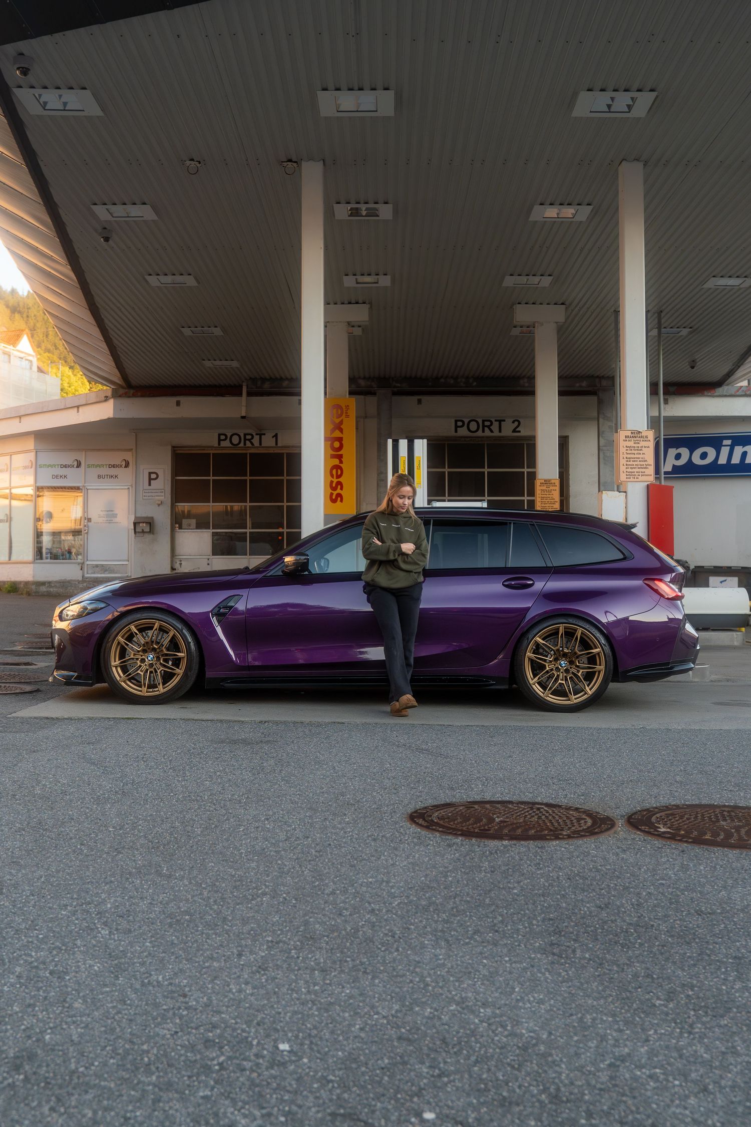 A sleek purple Audi R8 sports car parked in a covered parking area with gold wheels and custom styling.