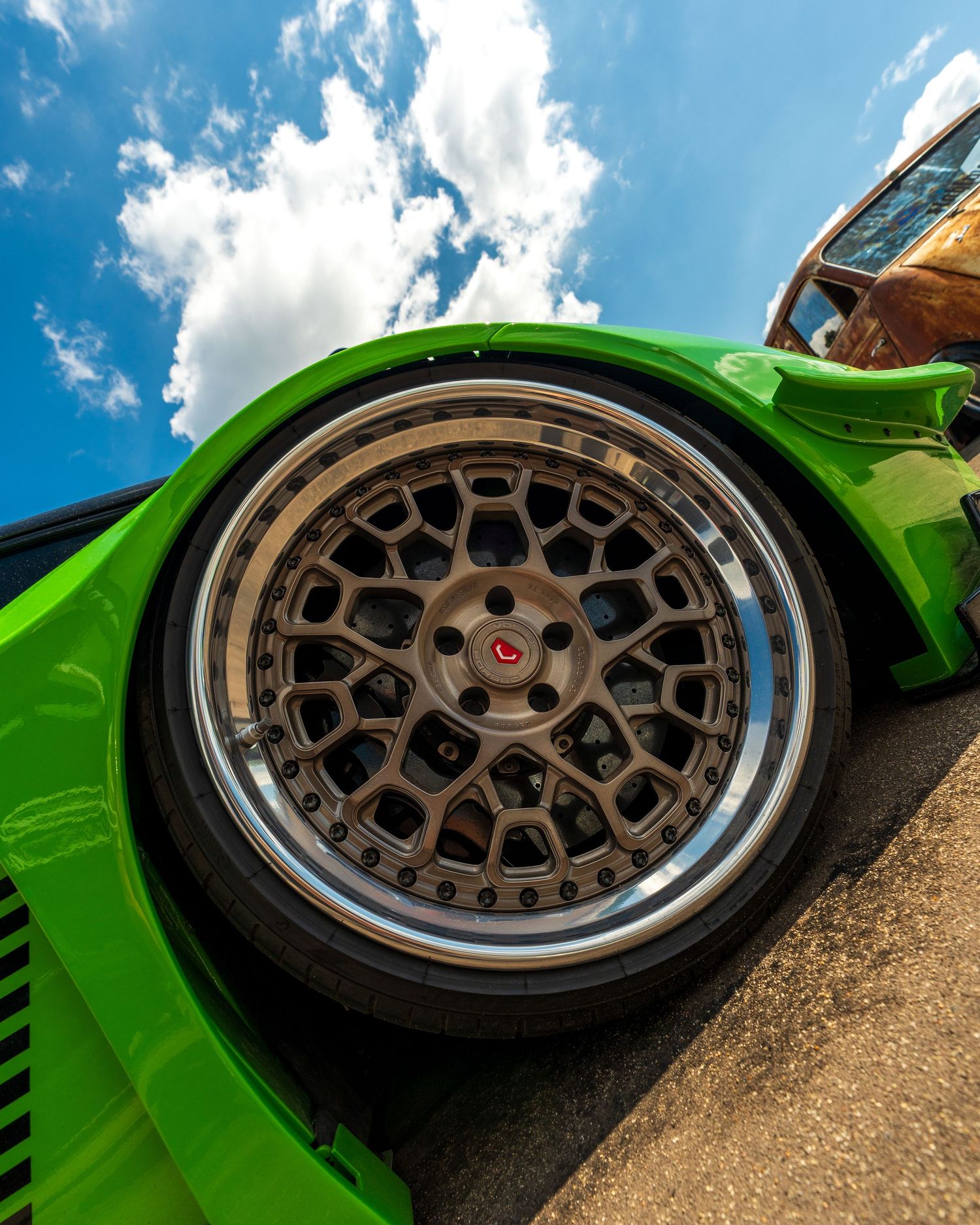 Close-up of bronze mesh-style aftermarket wheels on a bright green sports car.
