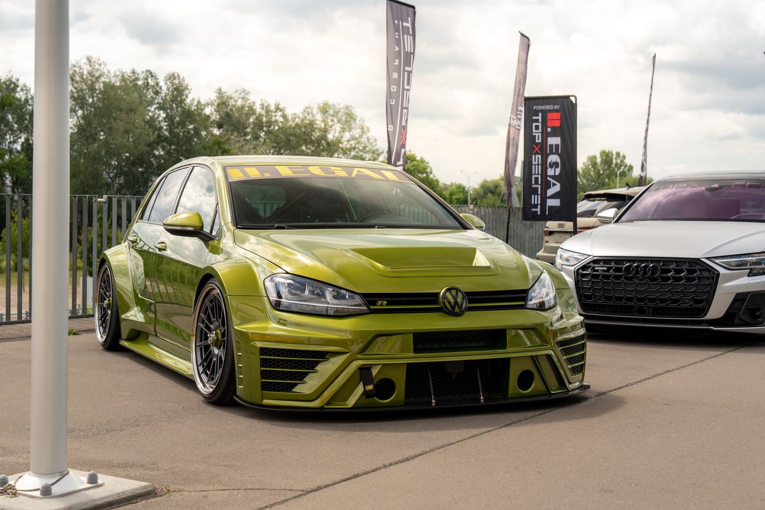 Lime green modified Volkswagen Golf with aggressive body kit and lowered suspension.