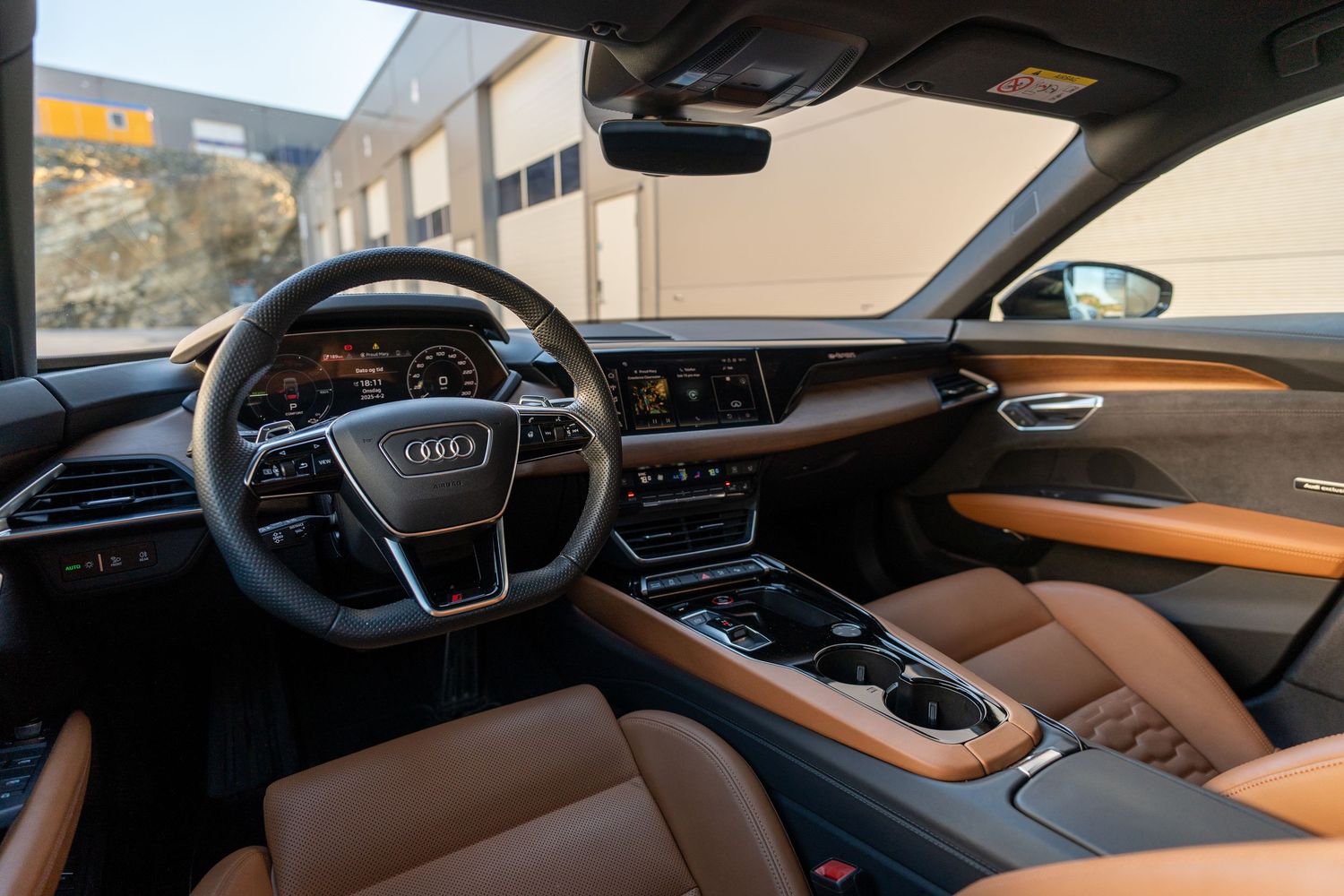 Luxury Audi interior featuring brown leather dashboard and modern digital displays.