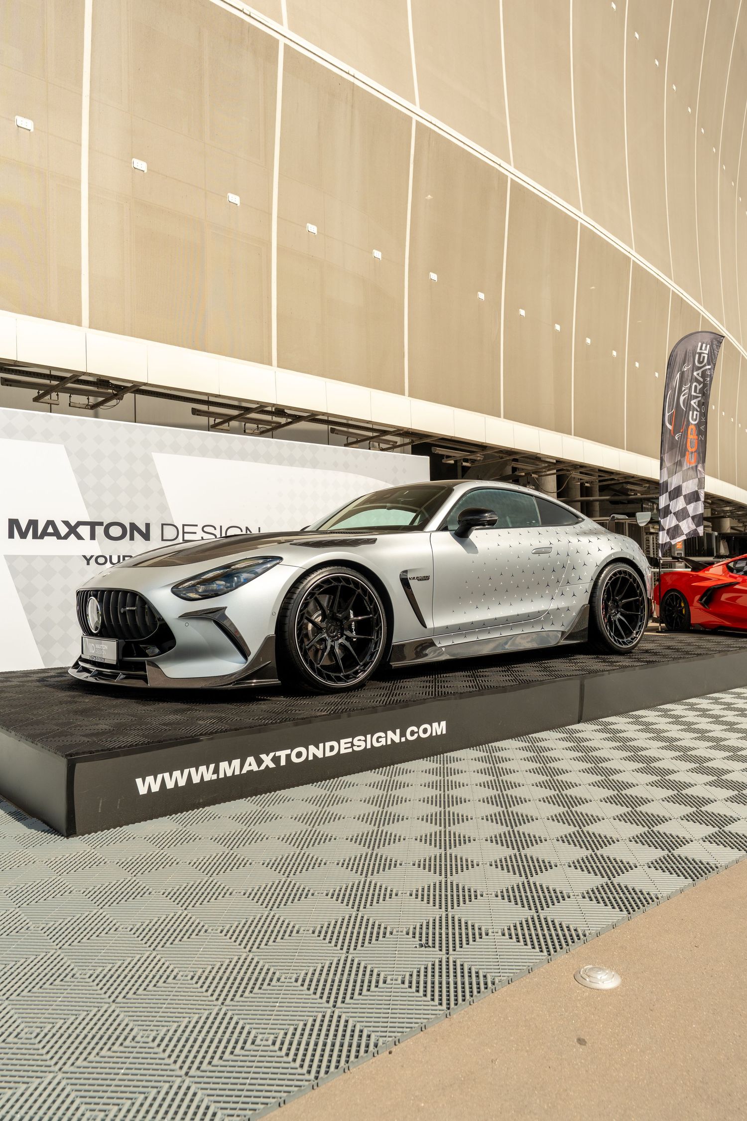 Silver modified sports car with wide body kit displayed at Maxton Design booth.
