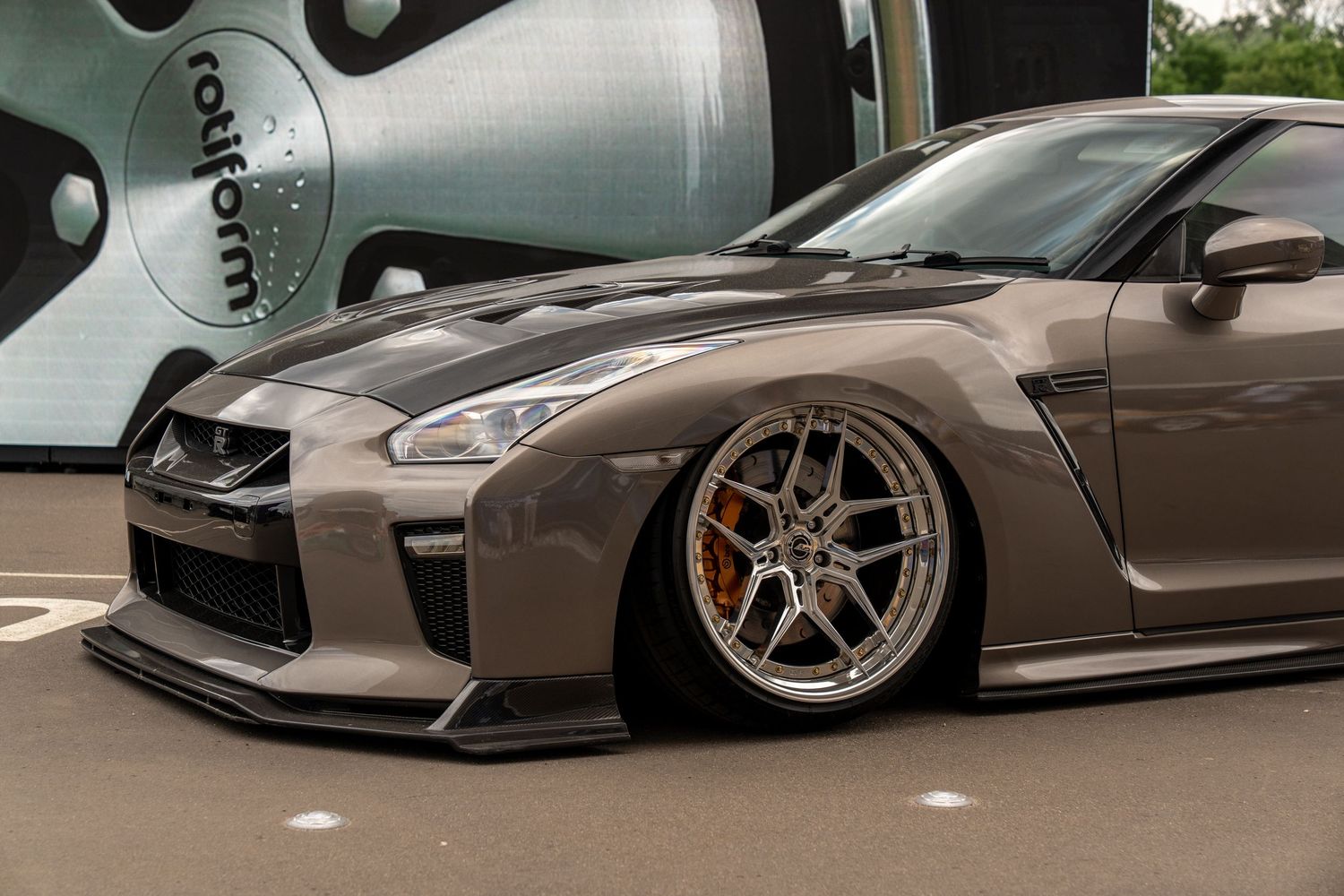 Lowered Nissan GT-R with custom wheels and aggressive body modifications.