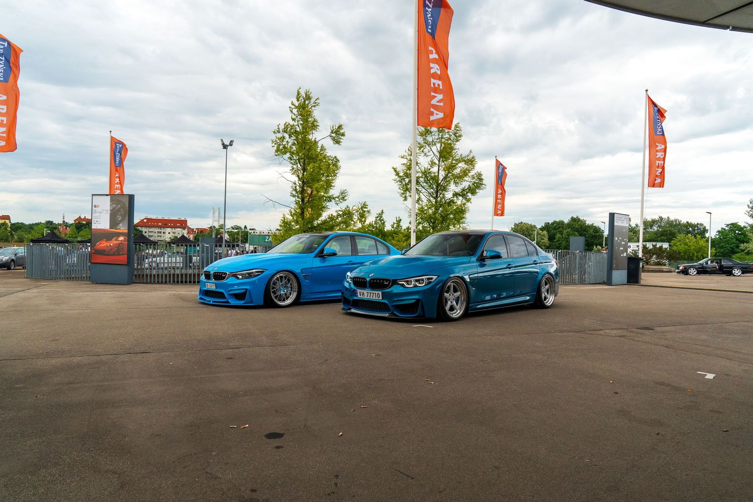 Line of bright blue modified cars displayed at an outdoor automotive event.
