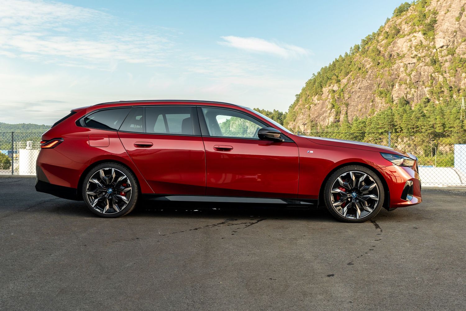 Low angle shot of a burgundy BMW M850i Gran Coupe highlighting its aggressive stance.