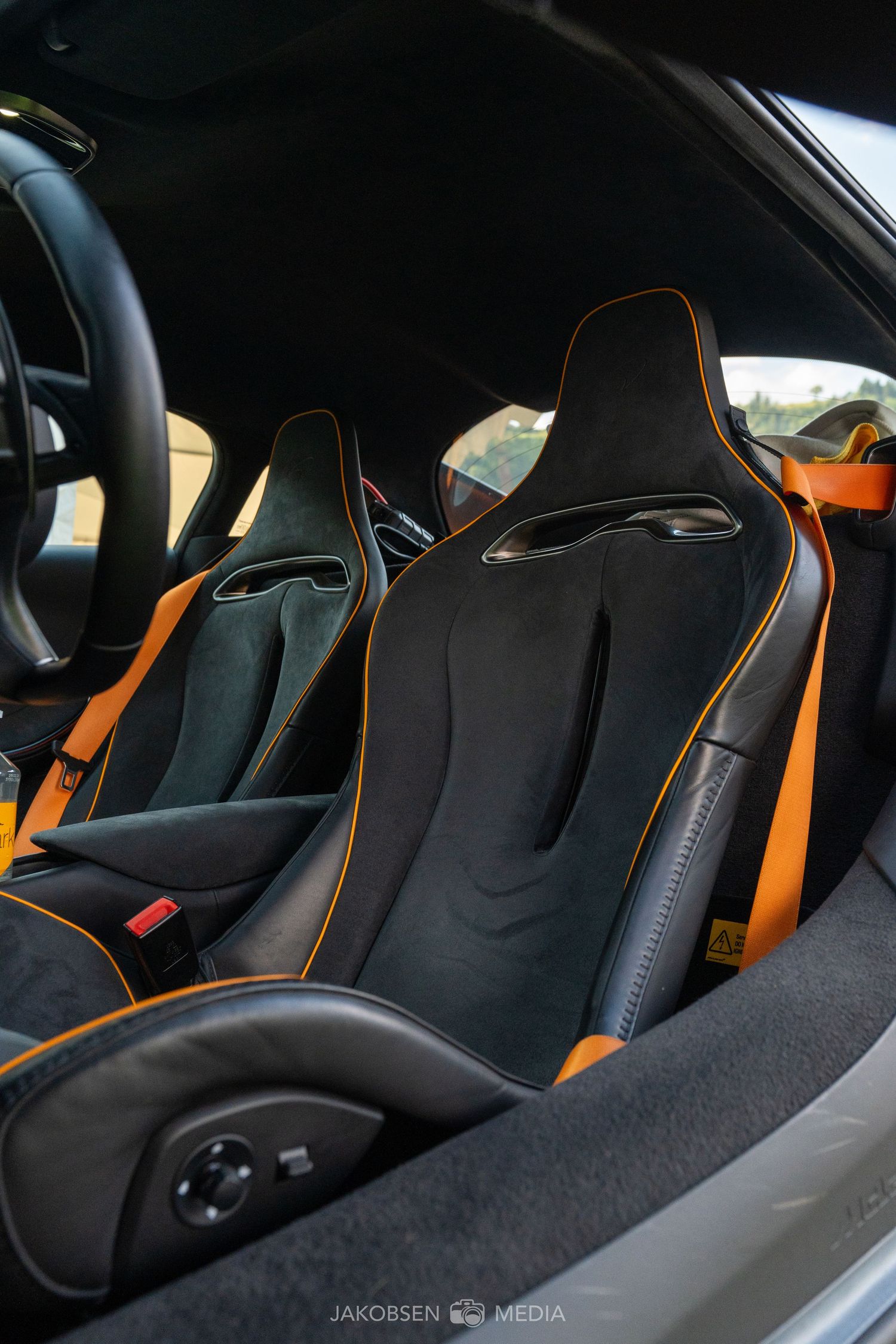 Black and orange sports car interior with racing seats featuring contrasting orange trim details.