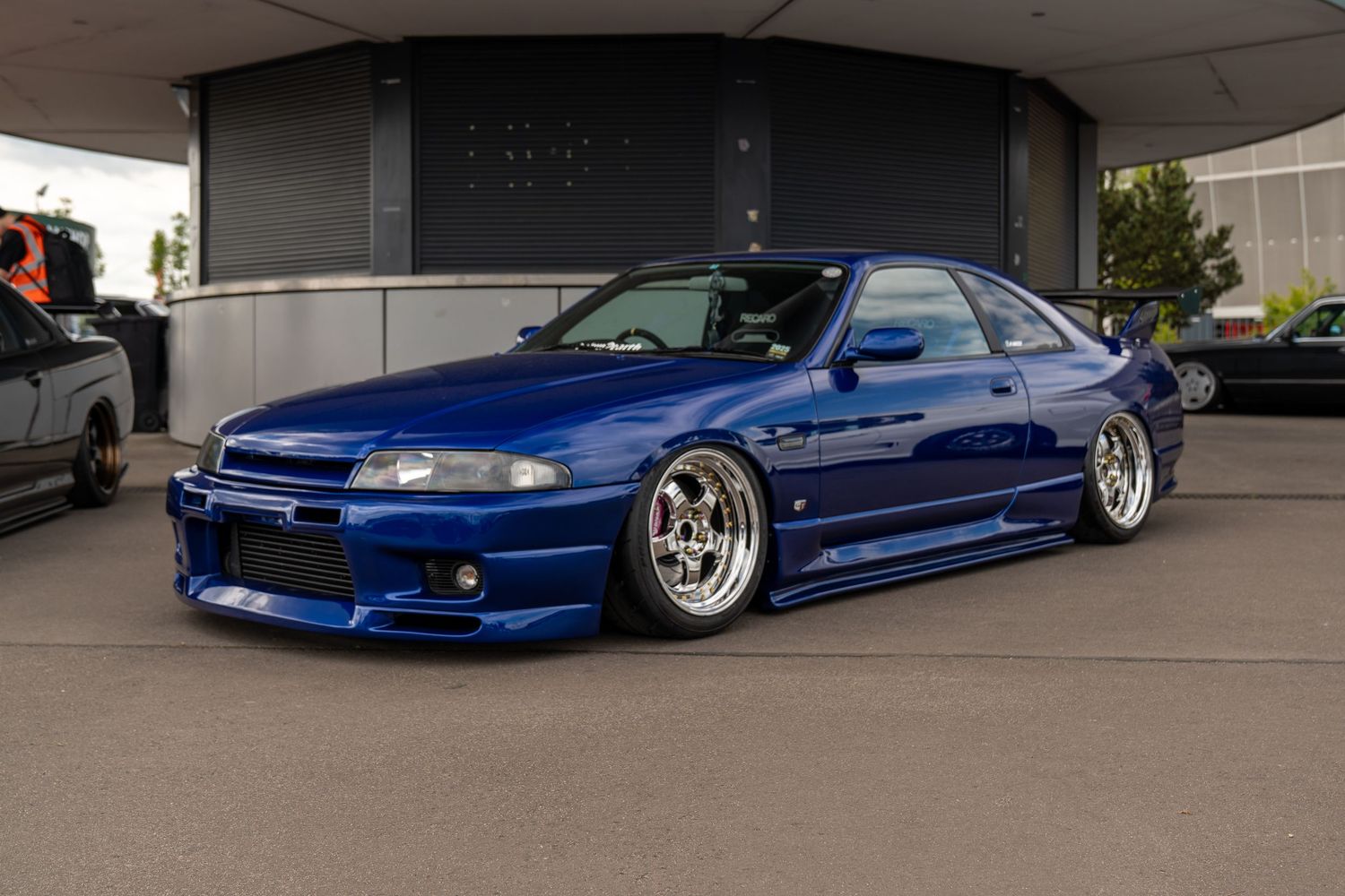 Row of lowered blue Nissan Skylines with custom wheels and body modifications.