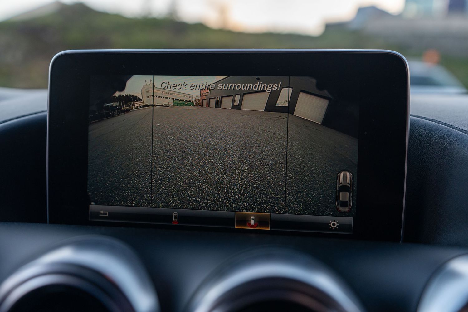 Mercedes infotainment display showing rear backup camera view mounted on dashboard.