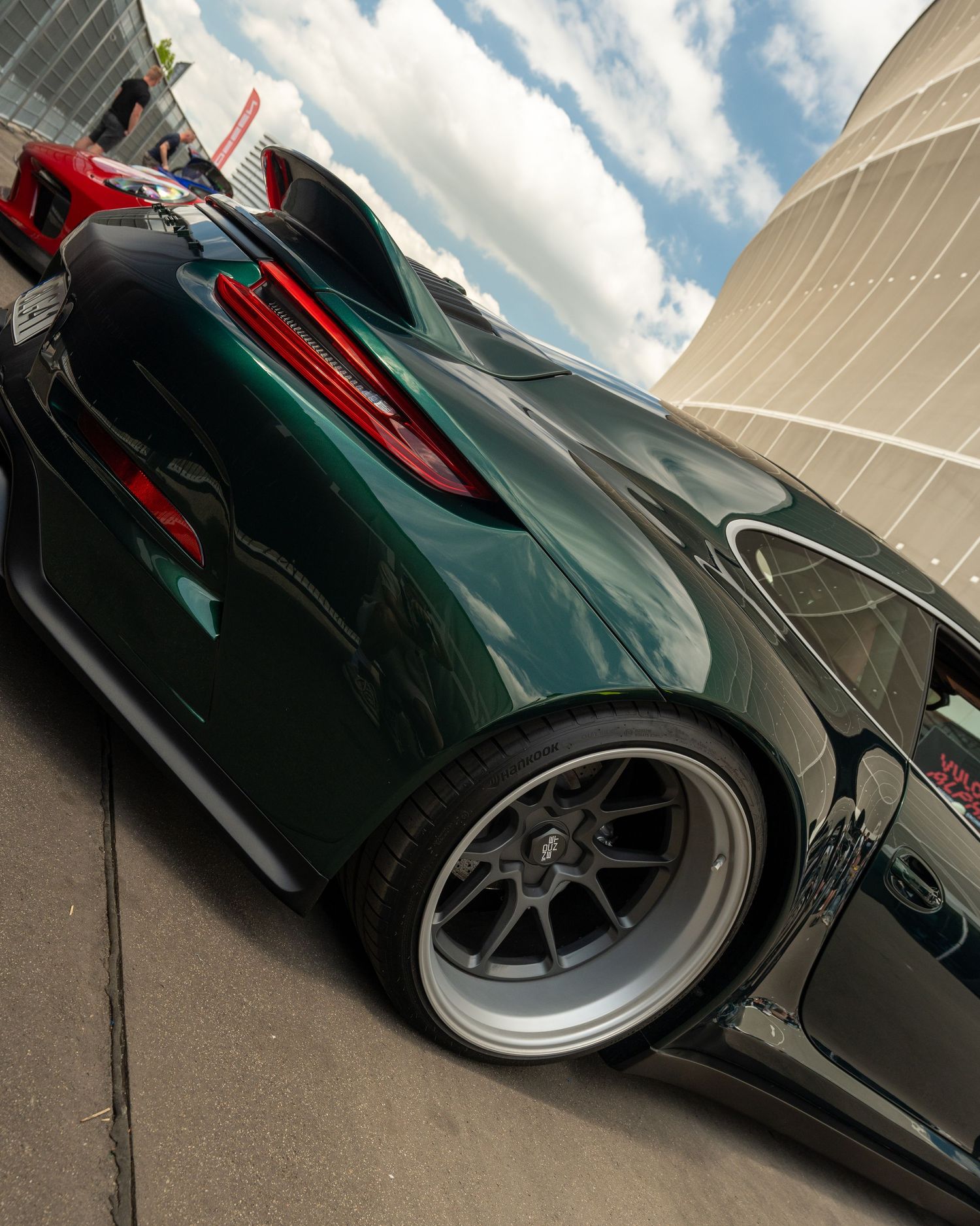 Low angle view of a custom dark green sports car showing sleek modified bodywork.