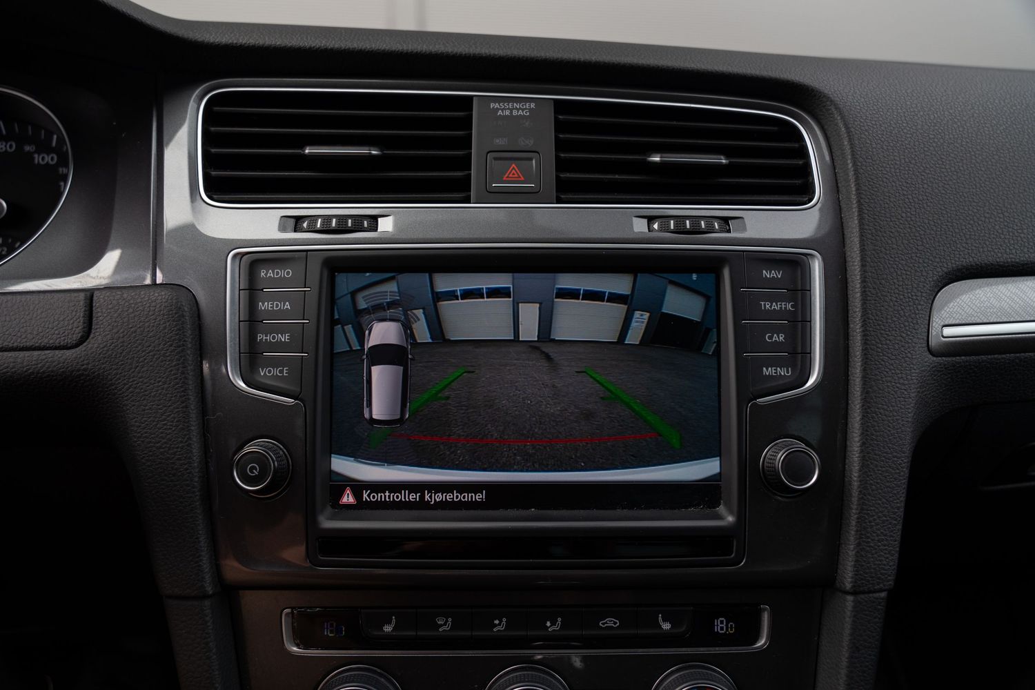 Interior view of a vehicle's center console featuring a digital display and climate control buttons.