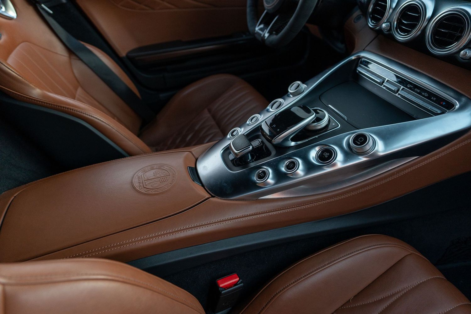 Center console detail showing gear selector and controls with brown leather trim.