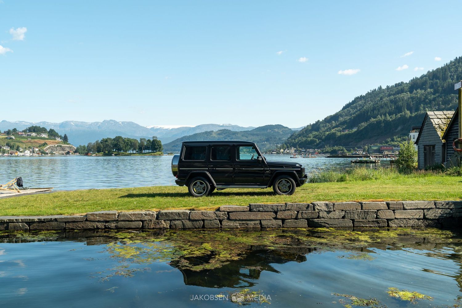 Beautiful coastal view with cars parked along a waterfront lookout point.