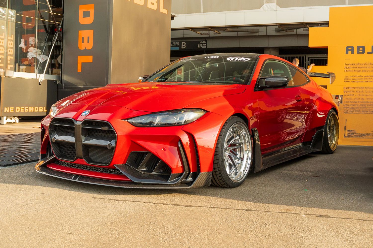 Five red modified sports cars lined up in a parking lot showcasing custom body kits and lowered suspensions.