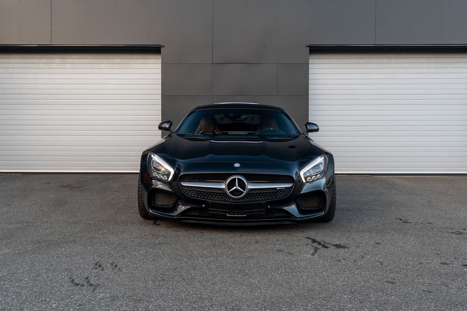 Front view of a black Mercedes-AMG GT showing distinctive wide grille and LED headlights.