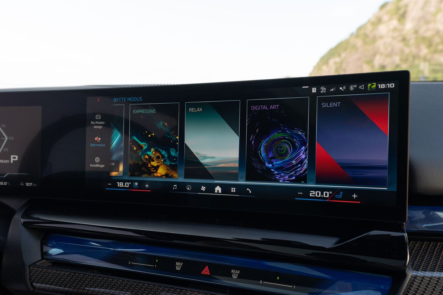 Wide curved display screen in BMW showing digital instrumentation and multimedia interface.