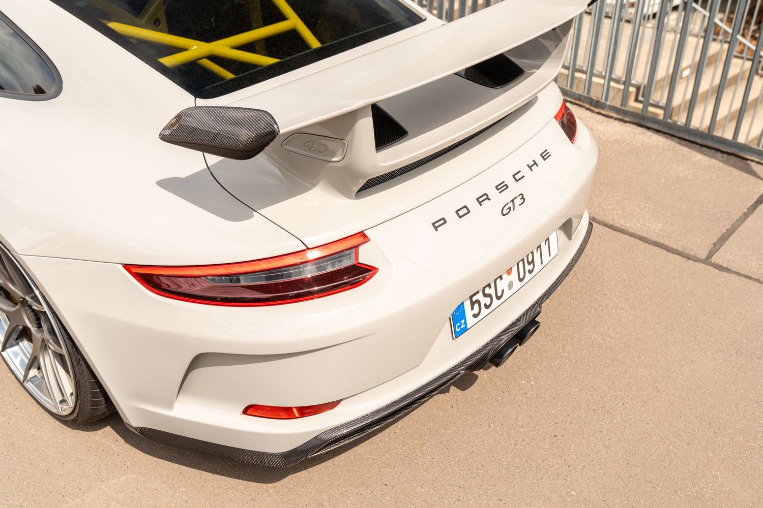 White Porsche 911 GT3 with racing-inspired modifications parked at automotive show.