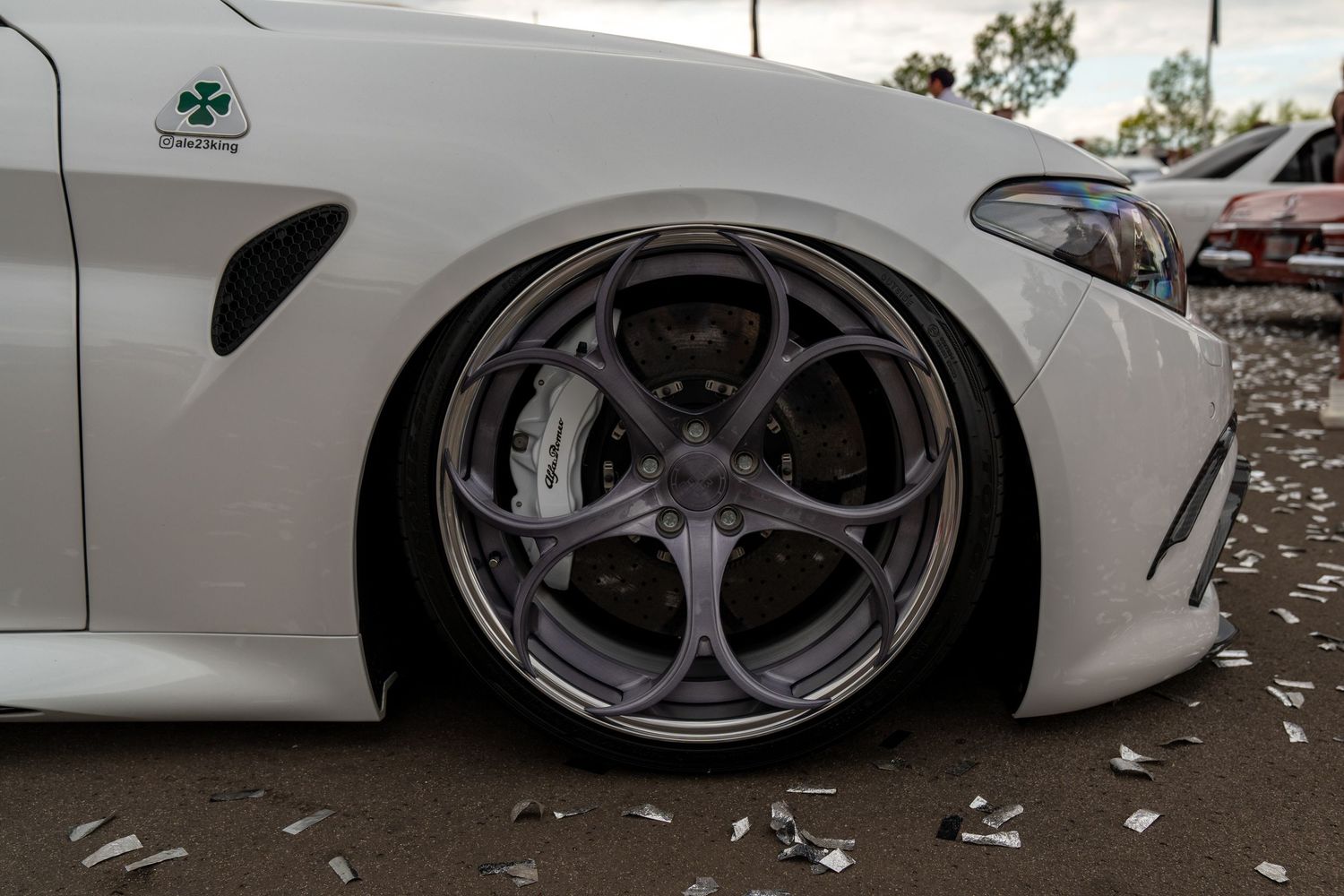 White BMW M-series wheel detail showing extreme negative camber fitment.