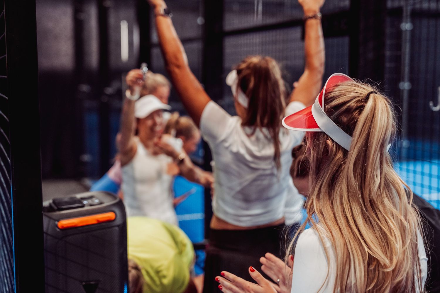 Energetic group workout session with participants raising arms in celebration.