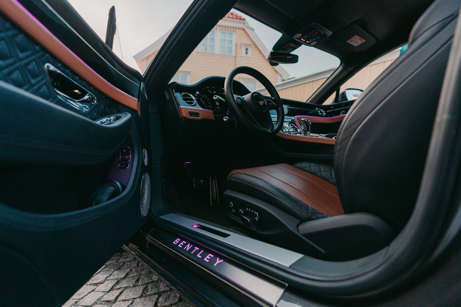 Luxury car interior featuring brown leather seats and modern dashboard controls.