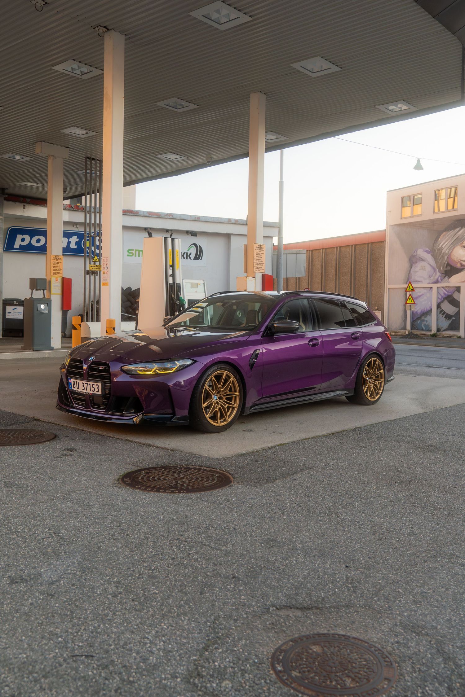 Modified purple BMW M4 with gold wheels shown from multiple angles at a gas station.