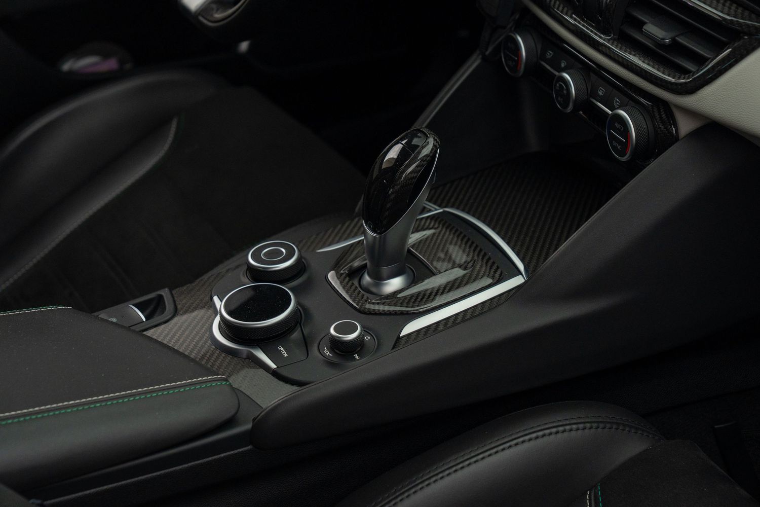 Modern car interior showing center console with media controls and gear selector.