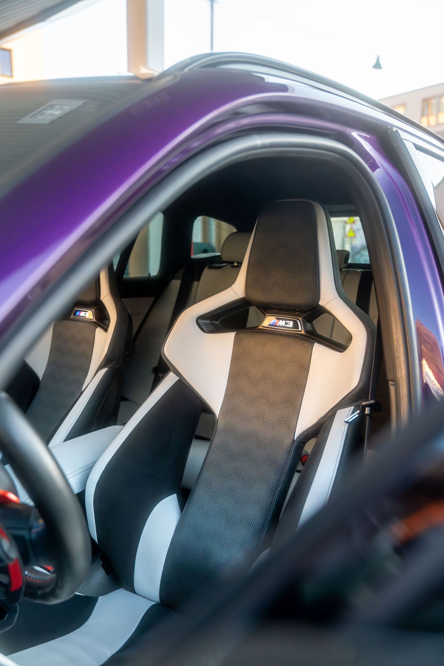 Sport bucket seats in black and grey upholstery shown from multiple angles inside a purple-tinted vehicle interior.