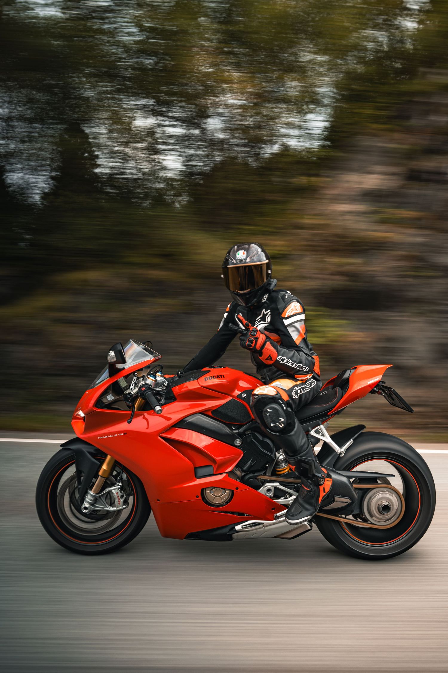 Motion-blurred shot of a red Ducati Panigale motorcycle being ridden at speed.