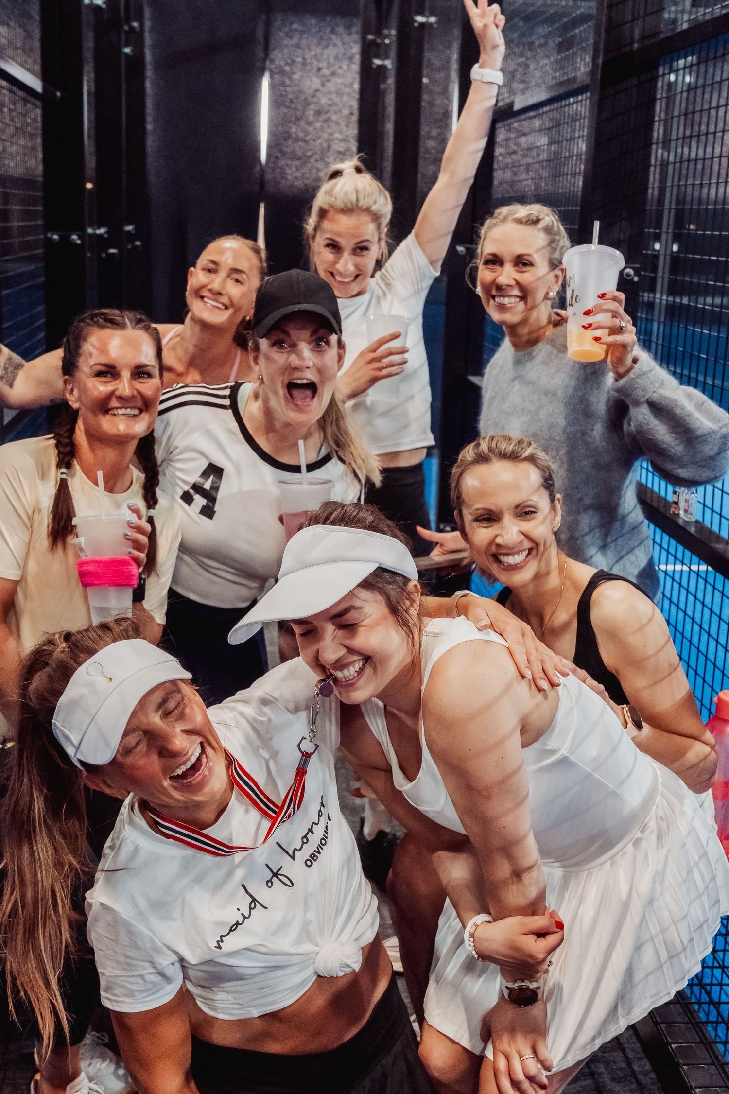 Happy players posing together for group photo after tennis match.