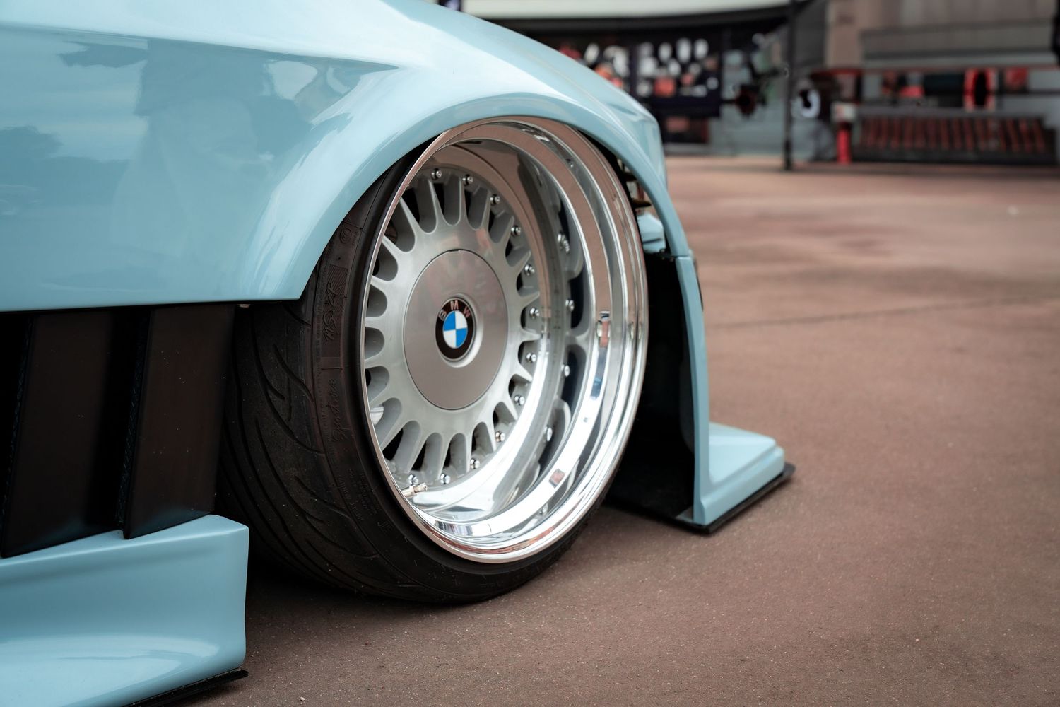 Detail shot of customized sports car with aftermarket wheels and suspension.