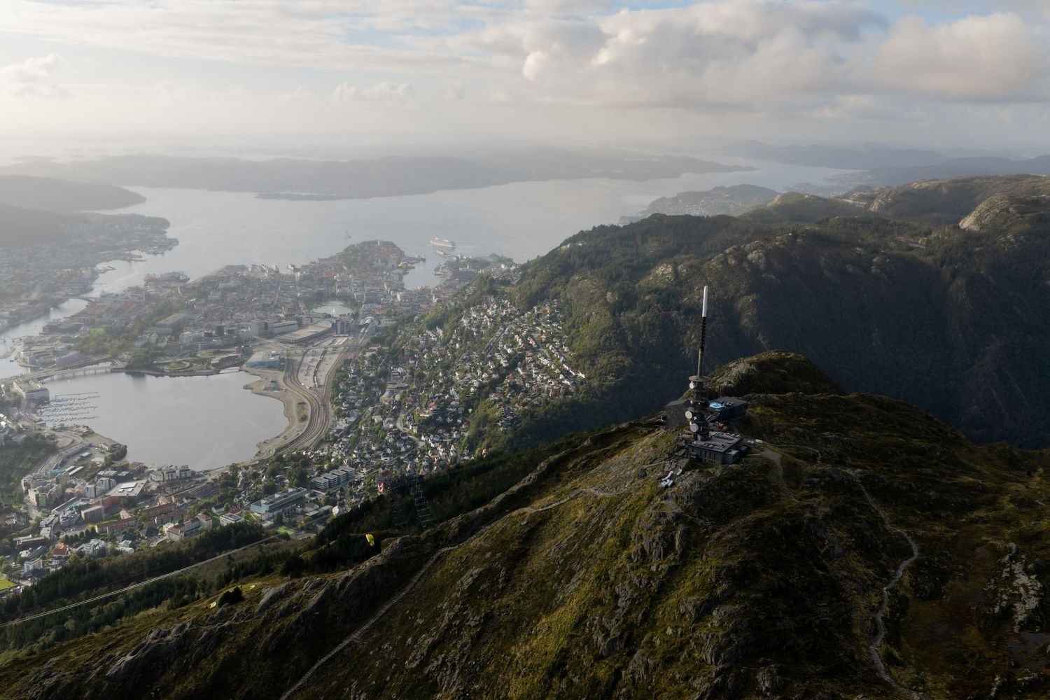 Aerial view of Bergen, Norway from Mount Ulriken with a communications tower and fjord in the background.