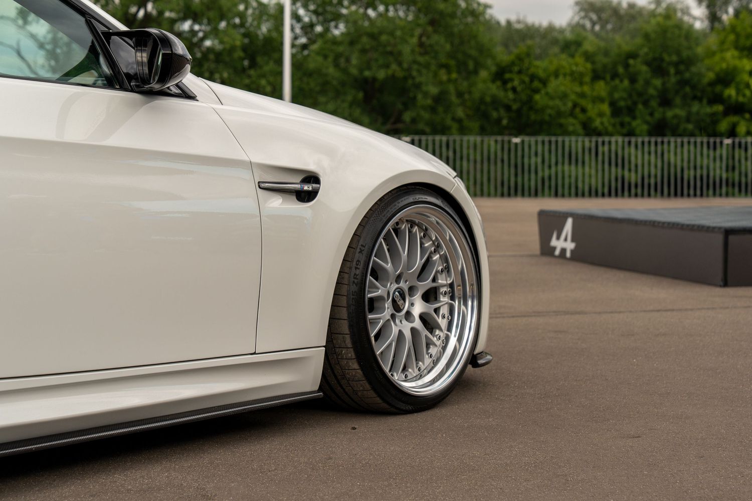Clean white modified luxury sedan showcasing detailed custom bodywork and wheels.