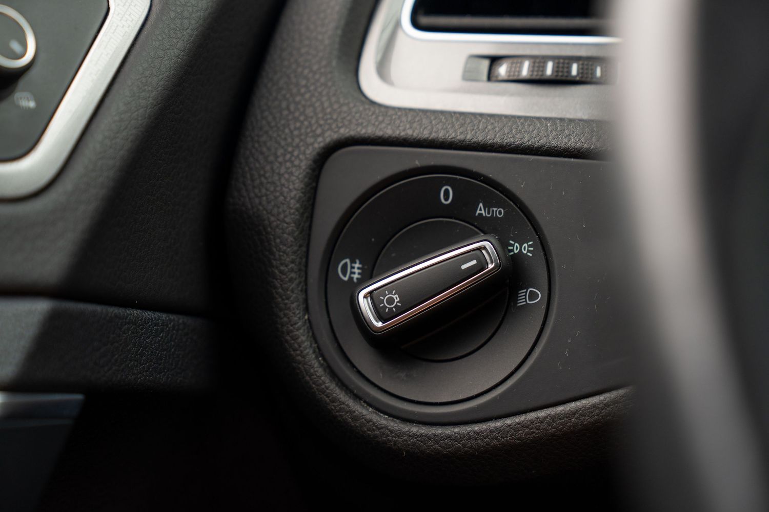 Close-up details of black interior controls and switches in a Volkswagen vehicle.