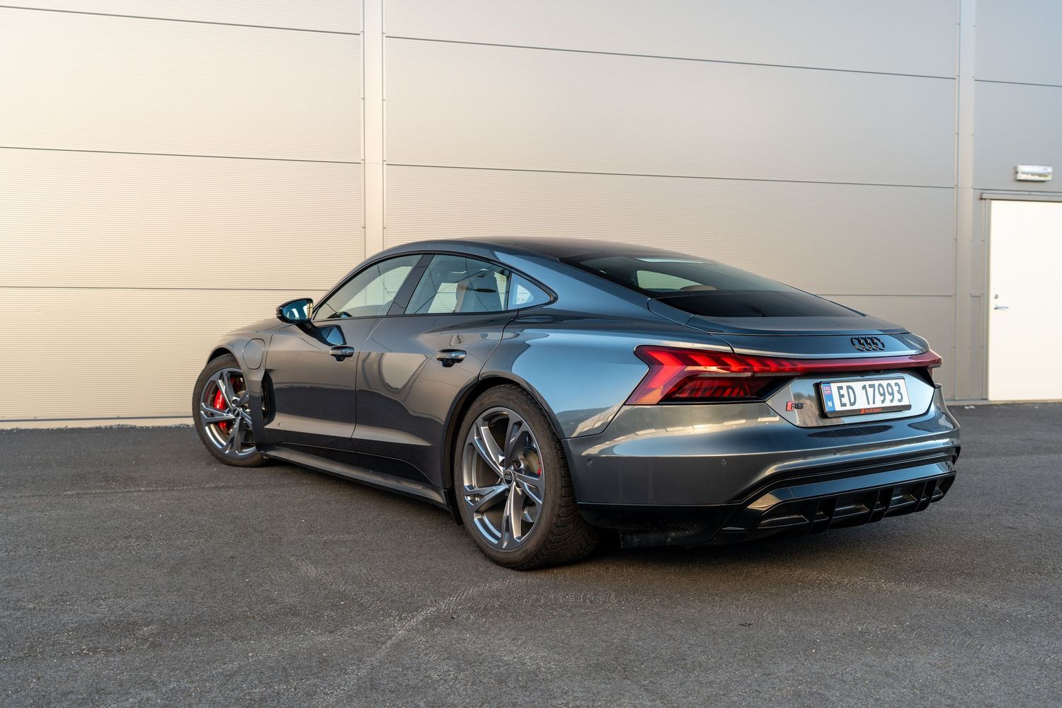 Rear quarter view of Audi RS e-tron GT showing sculpted body lines and distinctive LED taillights.