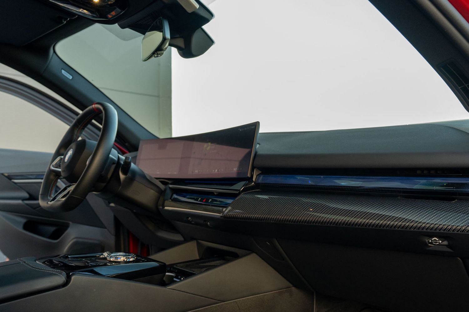 Modern car interior featuring a sleek dashboard with digital display screen and leather trim details.