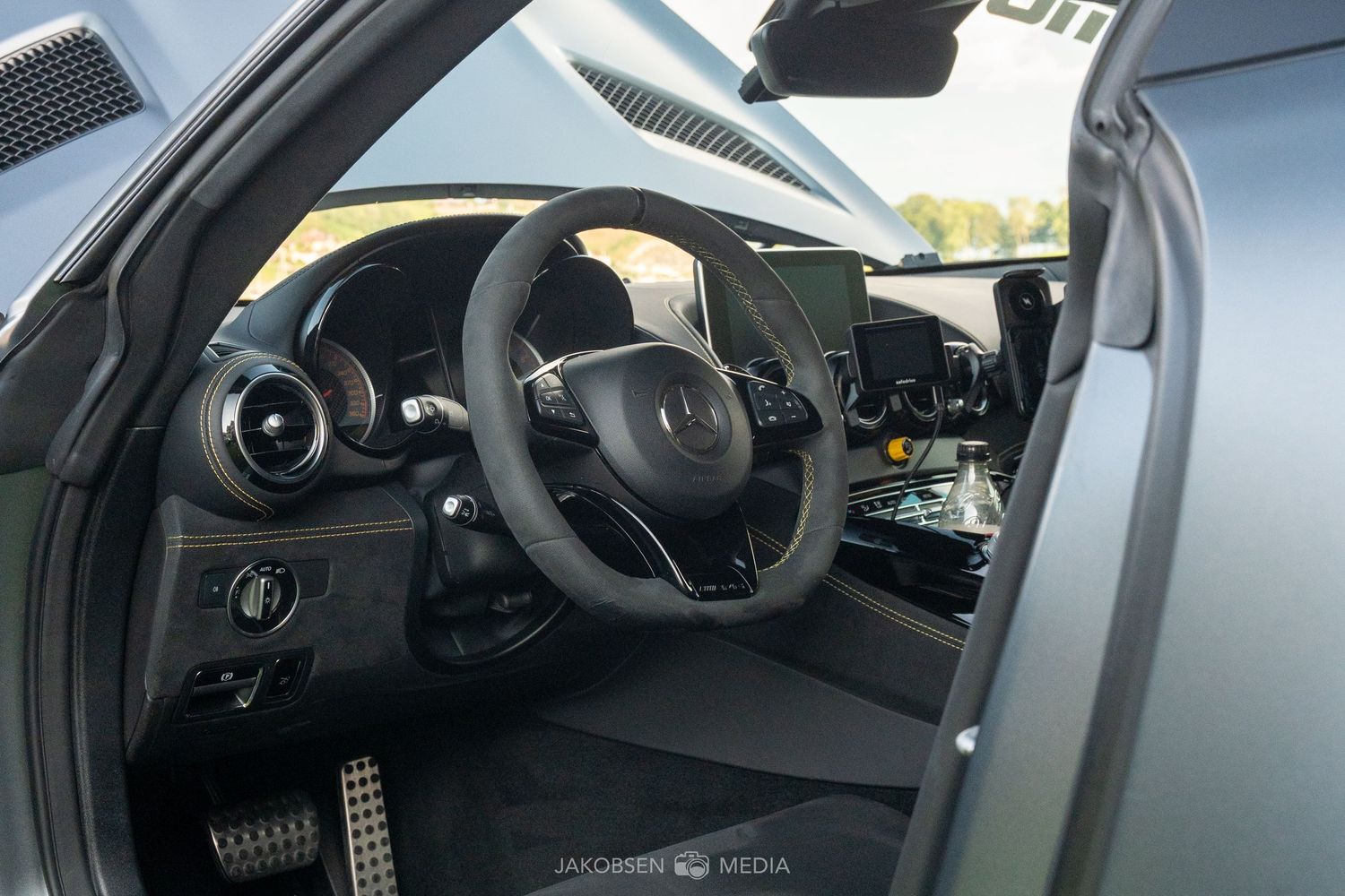 Interior dashboard view of a modern McLaren supercar showing digital displays and steering wheel.
