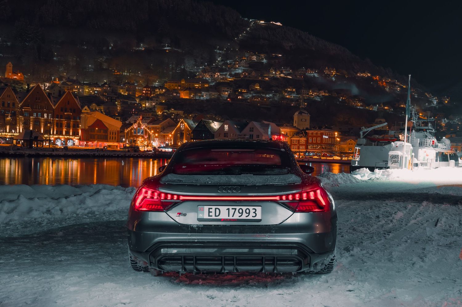 Mercedes AMG GT rear view parked in snowy Norwegian village at night.