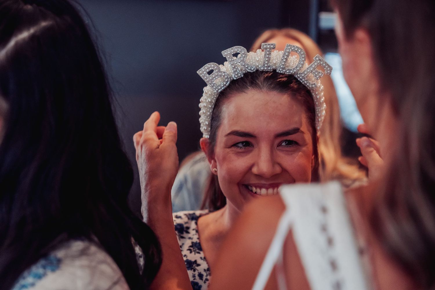 A joyful bride wearing an ornate tiara during her wedding celebration.