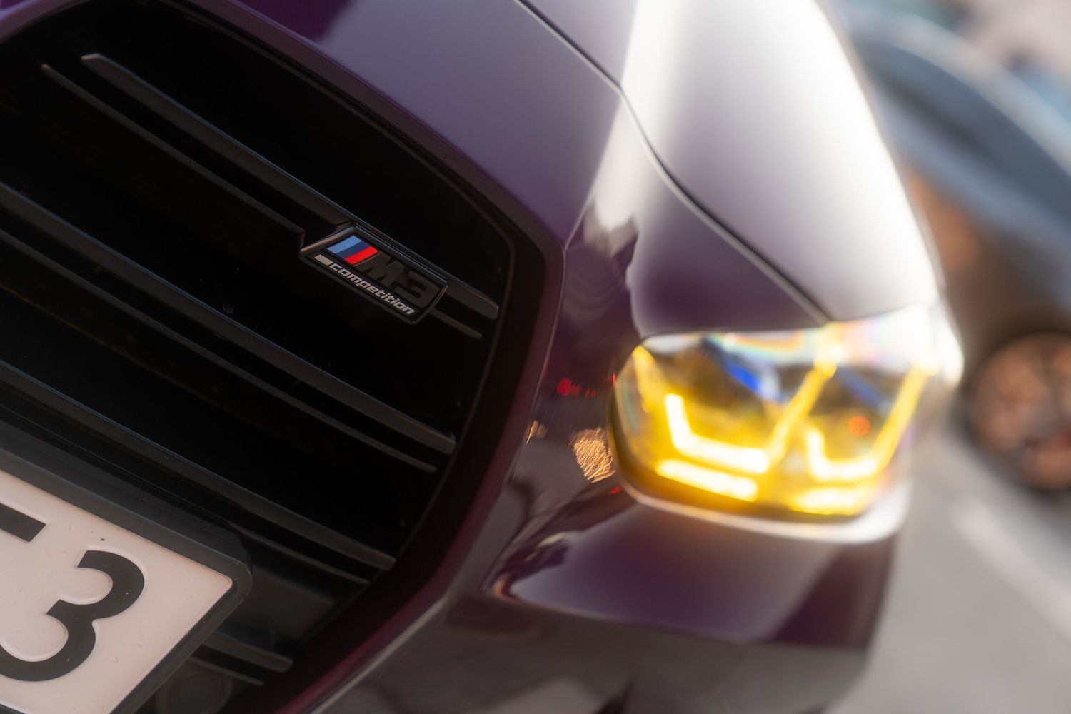 BMW headlight detail showing distinctive LED lighting signature in dramatic lighting conditions.