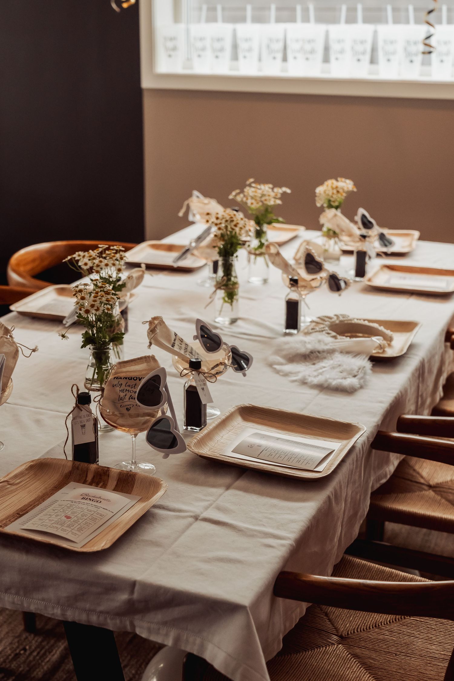 Elegant table setting with white tablecloth, baby's breath flowers, and rustic wooden chairs for an intimate gathering.