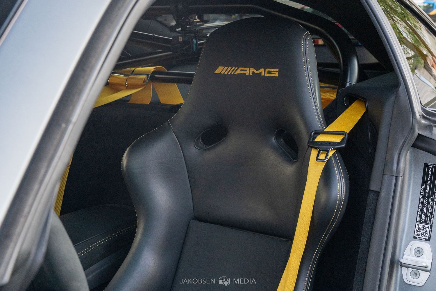 Black and yellow interior detail of Mercedes-AMG performance vehicle with racing seats.