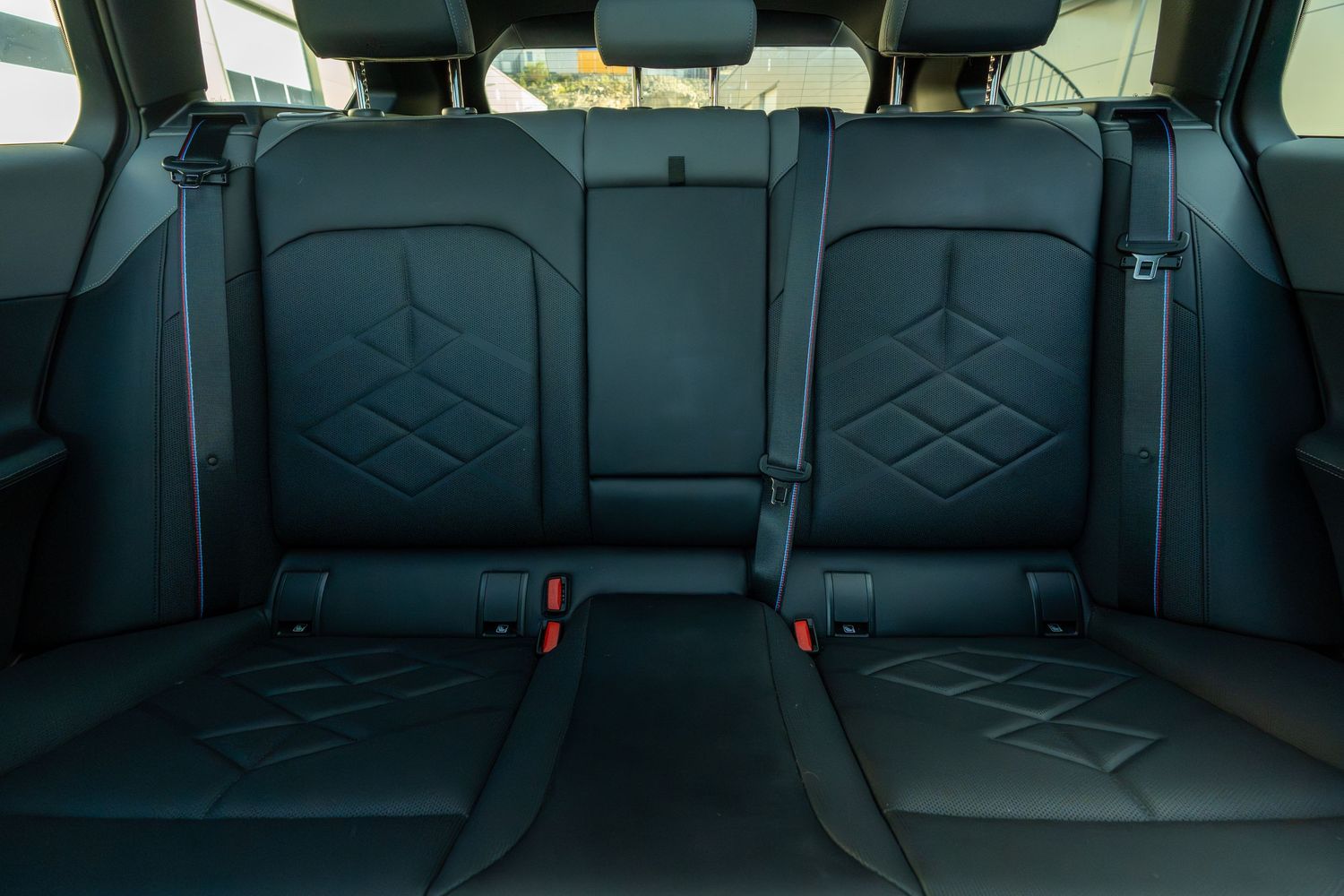 Panoramic view of black leather rear seats in a luxury vehicle interior.