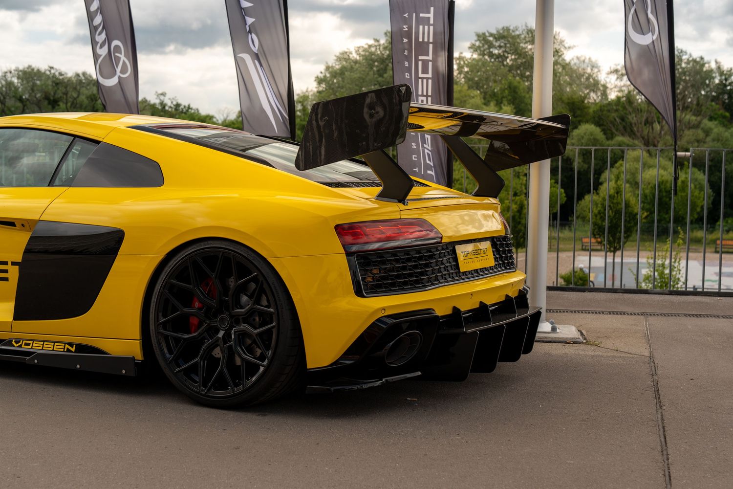 Yellow McLaren P1 supercar shown from multiple angles at a gas station with dramatic sky in background.