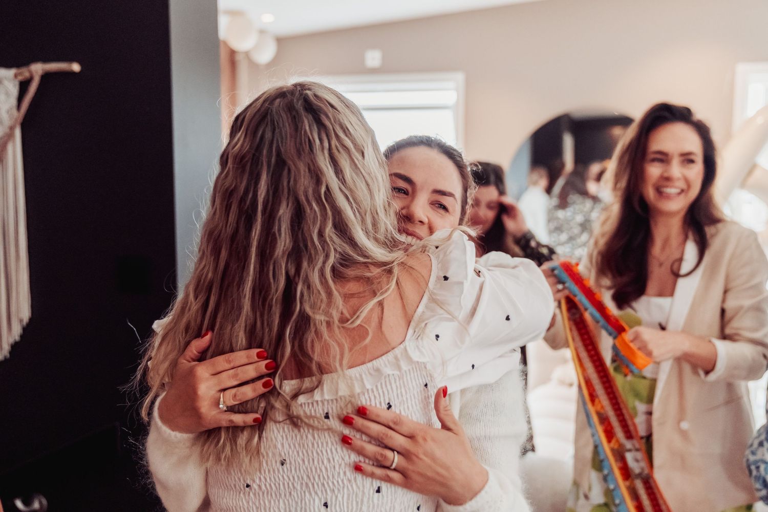 People sharing embraces and congratulations at a celebration event.