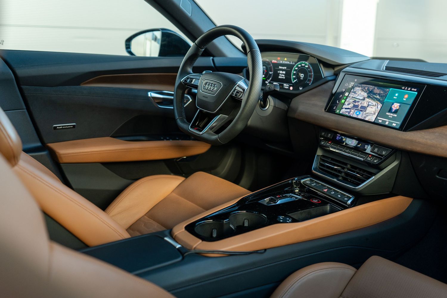 Luxurious tan and black interior of modern Audi featuring digital displays and premium materials.