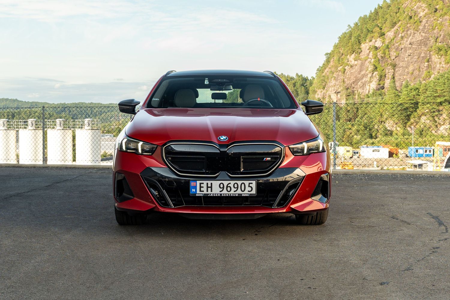 A red BMW 8 Series sports car shown from multiple angles parked against mountainous landscape backdrops.