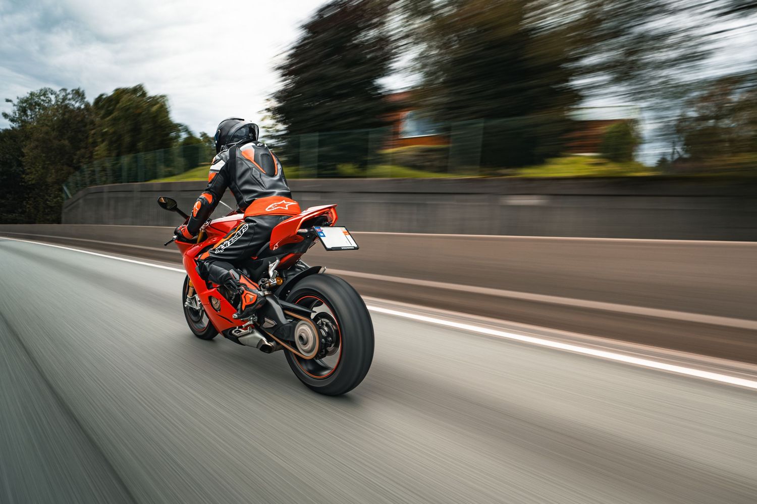 Red motorcycle in motion on highway with motion blur effect.