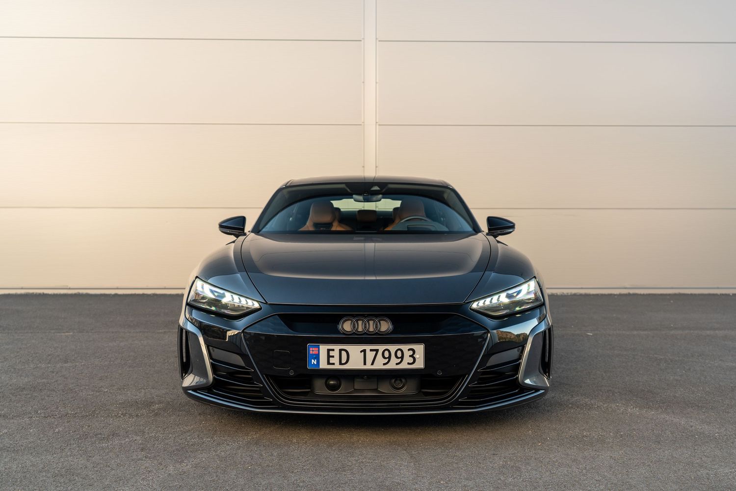 Front view of a sleek grey Audi RS e-tron GT with aggressive LED headlights.