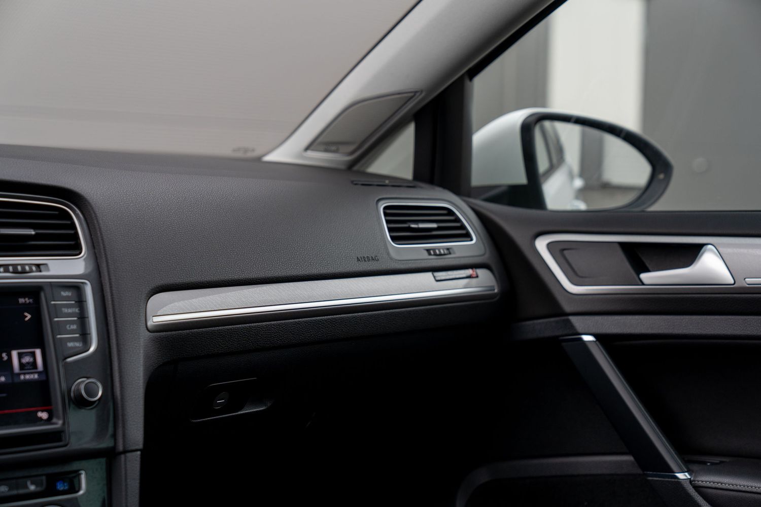 Modern dashboard and interior trim details of Volkswagen Golf with black and silver accents.
